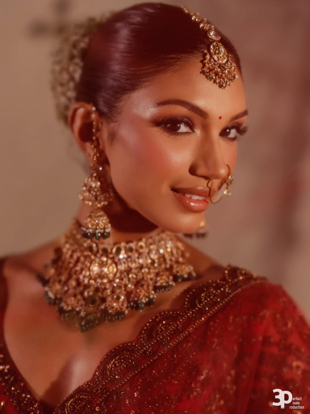 South Asian bride in red with gold jewellery, makeup by Sonam Singh